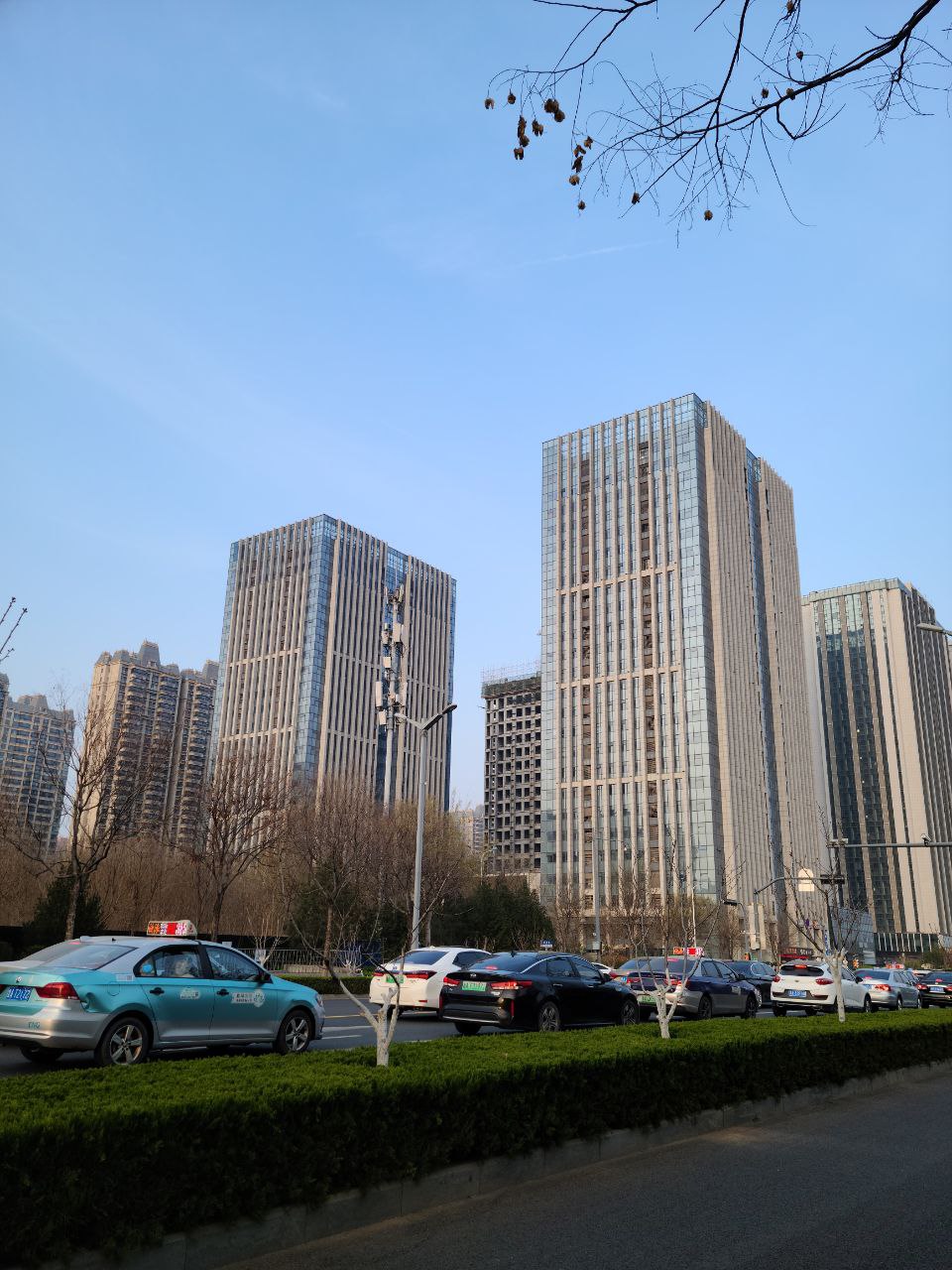 cars parked in a parking lot in front of a group of tall buildings